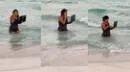 Mujer ingresa al mar con su laptop y hace videollamada: "Vacaciones, pero a qué costo"