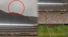 Hinchas de la selección peruana alientan desde un cerro mientras entrenan en el Monumental