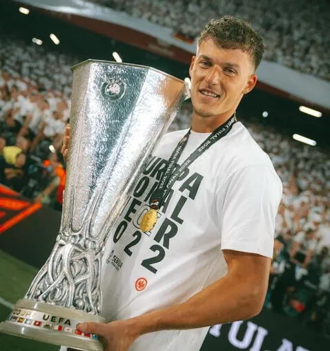  <em>Ajdin Hrustic, número 10 de Australia, con el trofeo de la Europa League</em> 2021-22.   