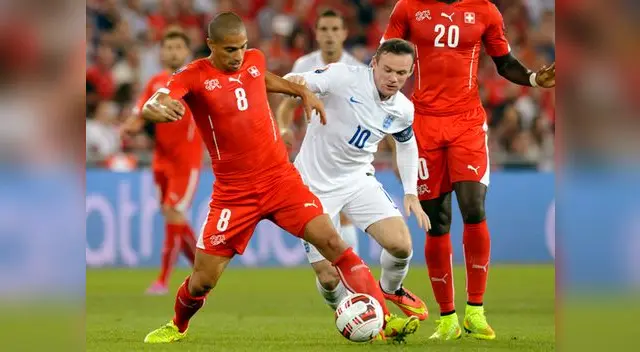 Suiza vs. Inglaterra: Wayne Rooney disputa el balón con Inler. Suiza vs. Inglaterra: Wayne Rooney disputa el balón con Inler.