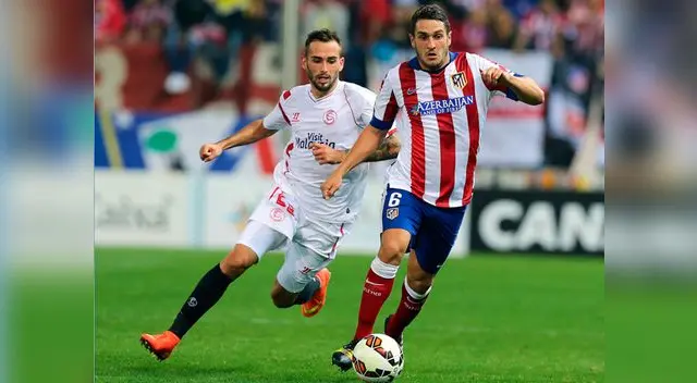Atlético de Madrid vs. Sevilla: Koke Resurrección avanza ante la marca de un jugador sevillista.