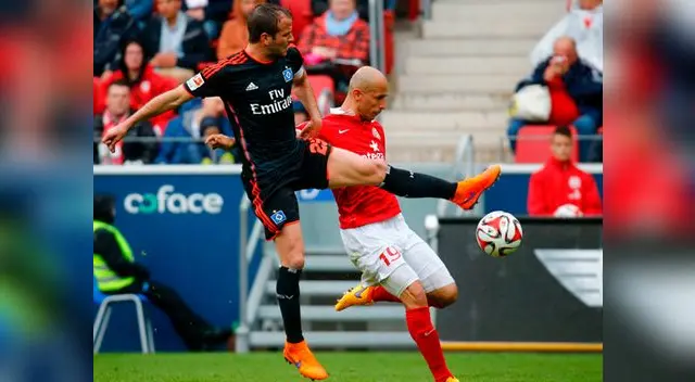 Elkin se dispone a impactar el balón cuando se interpone Rafael van der Vaart. Elkin se dispone a impactar el balón cuando se interpone Rafael van der Vaart.