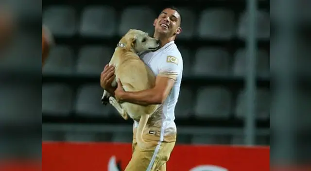 Gerardo Alcoba se lleva cargado al perro para entregárselo al cuarto árbitro.