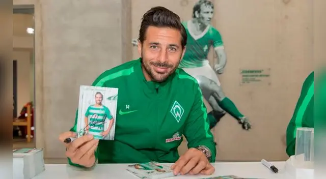 Claudio Pizarro posa junto a una postal suya en una firma de autógrafos en Alemania.