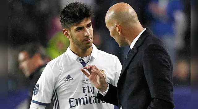 Zinedine Zidane conversa con Marco Asensio durante un partido del Real Madrid.
