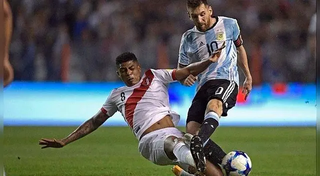 Wilder Cartagena disputa un balón con Lionel Messi.