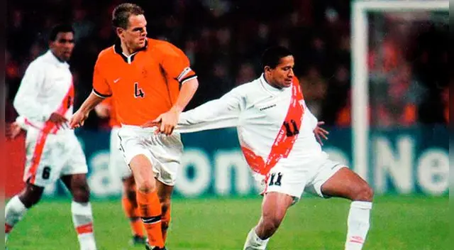 Frank de Boer disputa un balón con Carlos 'Kukín' Flores.