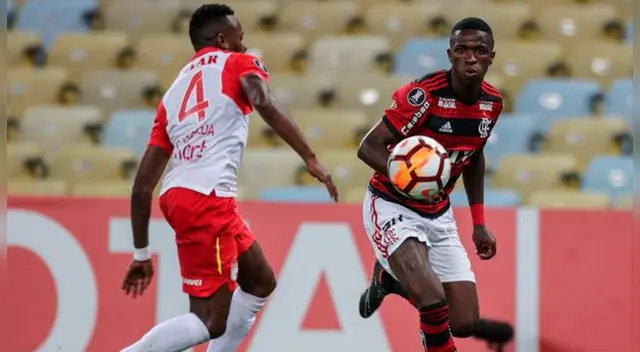 Vinícius Jr disputa un balón con Carlos Arboleda.