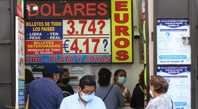 Ciudadanos preguntando sobre el precio del dólar en una casa de cambio.