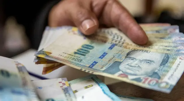 Sujeto agarrando con su manos varios billetes de 100 soles. Sujeto agarrando con su manos varios billetes de 100 soles.