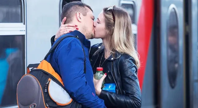 Pareja besándose en la estación del tren.