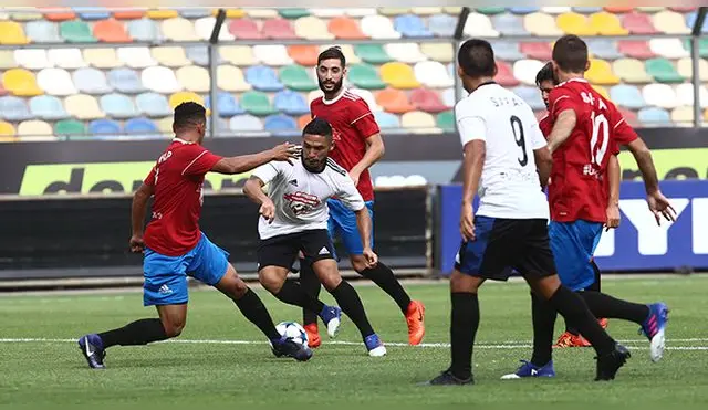 Joel Sánchez gambetea a Arquímedes Figuera ante la mirada de los otros jugadores.