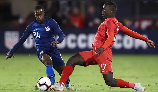Luis Advíncula y Jonathan Amon luchando el balón en amistoso entre Perú y Estados Unidos. Foto: FPF