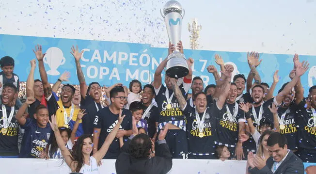 Los jugadores de Alianza Lima celebran con la copa de campeón.