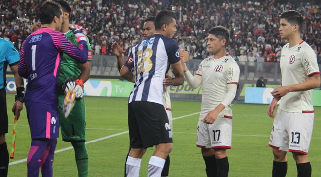 Los jugadores de Alianza Lima y Universitario en un saludo previo a un clásico