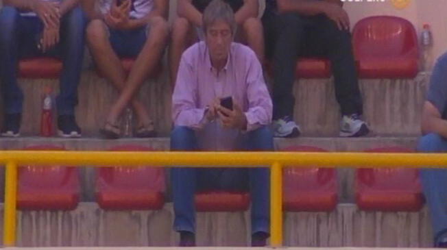 Germán Leguía mira su celular en medio de las celebraciones por los goles de Ruidíaz.