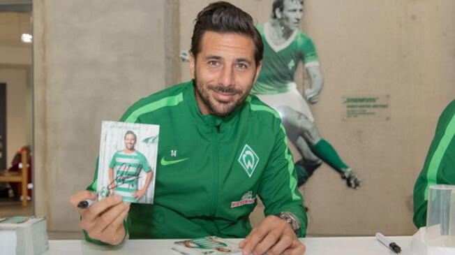 Claudio Pizarro posa junto a una postal suya en una firma de autógrafos en Alemania.