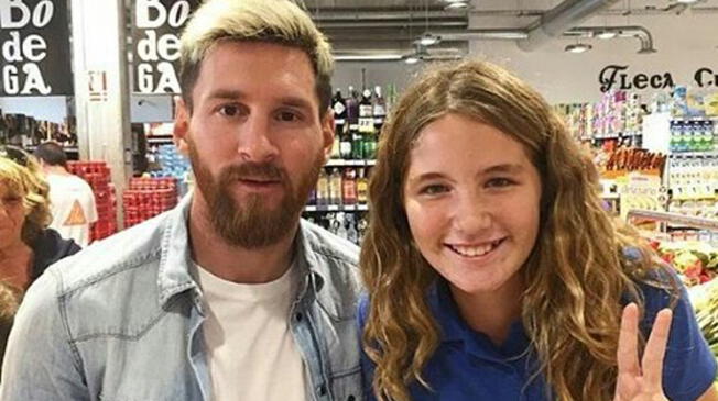 Lionel Messi posa junto a una joven fanática en un supermercado. 