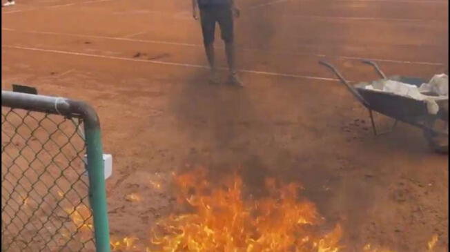 La cancha del polvo de ladrillo siendo quemada por la organización del Challenger de Marruecos.