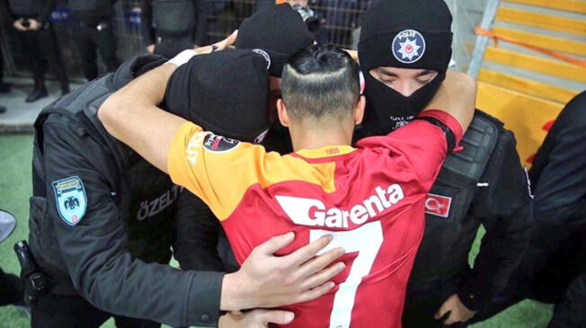 Yasin Oztekin abraza a tres policías en homenaje a las víctimas de Estambul.