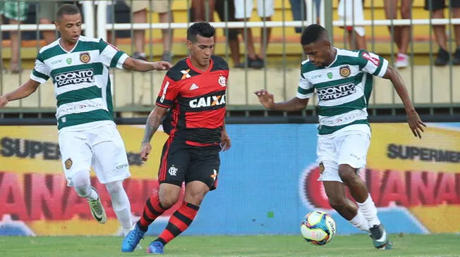 Miguel Trauco conduce el balón ante dos rivales del Madureira.