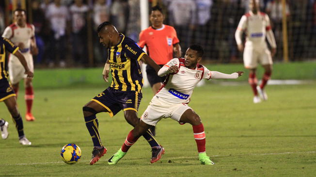 Alberto Quintero disputa un balón con Paulo Goyoneche.