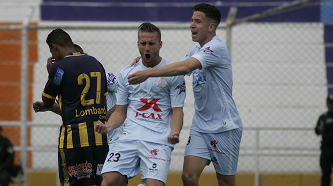 Adrián Ugarriza celebra un gol con Danilo Carando ante Sport Rosario.