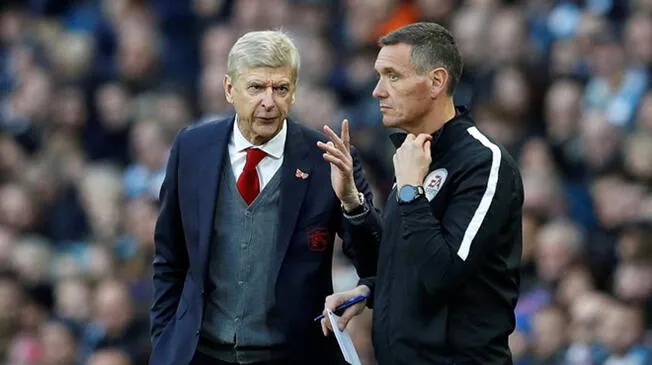Arsene Wenger le llama la atención a un árbitro durante el Manchester City-Arsenal.