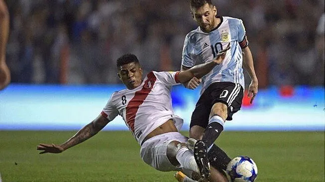 Wilder Cartagena disputa un balón con Lionel Messi.
