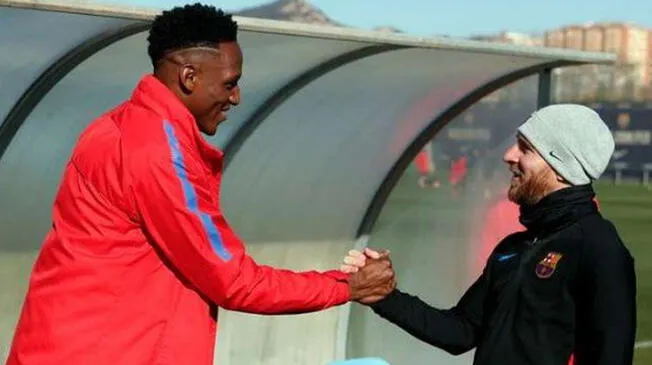 Yerry Mina saluda a Lionel Messi en un entrenamiento del Barcelona.