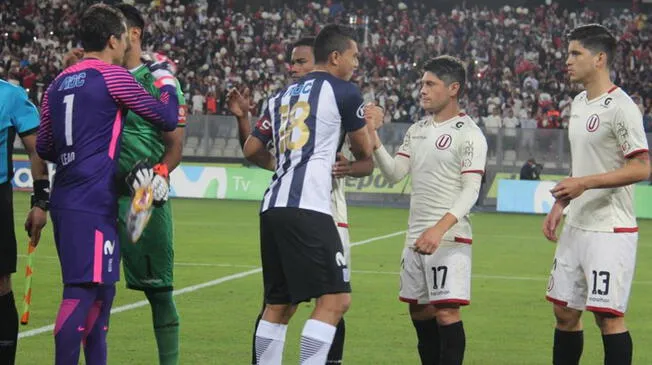 Los jugadores de Alianza Lima y Universitario en un saludo previo a un clásico