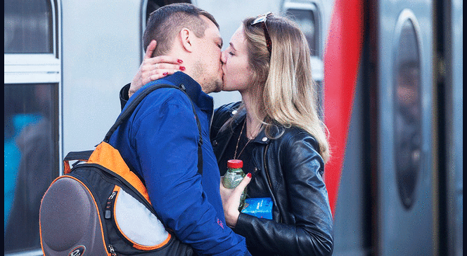 Pareja besándose en la estación del tren.