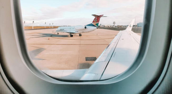 Pasajero observando el exterior desde la ventana de un avión.