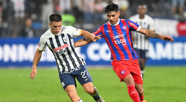 Catriel Cabellos defendiendo el balón ante la marca de un jugador de Cerro Porteño