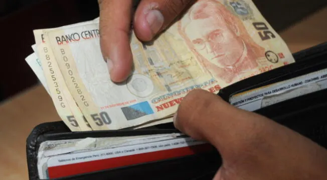Personas colocando billetes en su billetera.